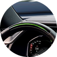 Steering wheel with illuminated green light bar indicating Super Cruise is active.