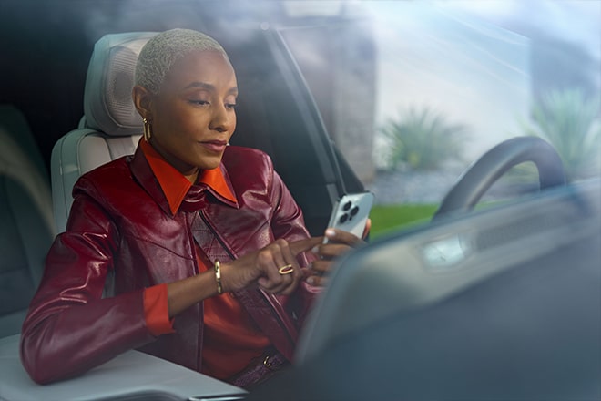 A woman using her smartphone to use OnStar remote commands.