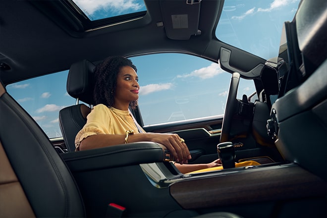 A woman using OnStar hands-free driving and real-time maps.