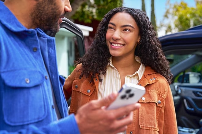 Un couple utilisant un smartphone pour utiliser OnStar.