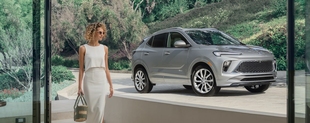 An OnStar-subscribed Buick SUV parked at a driveway as a person passes by.