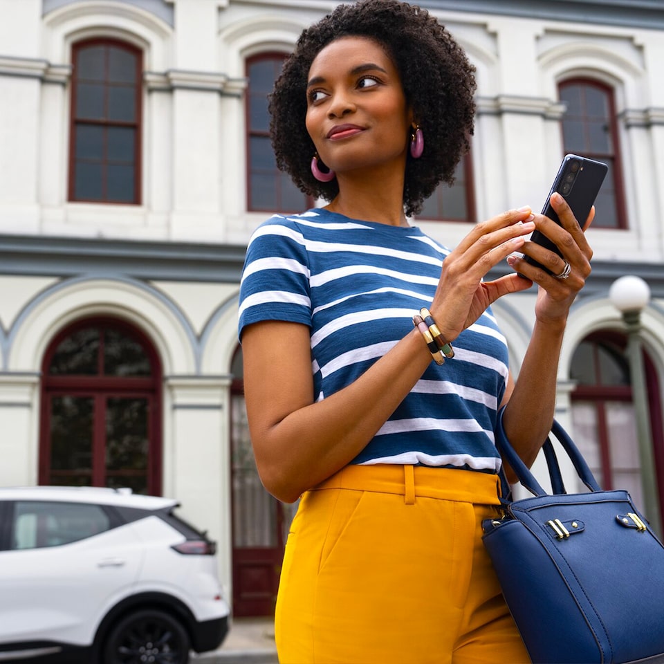 Person using a mobile phone walking in the street.