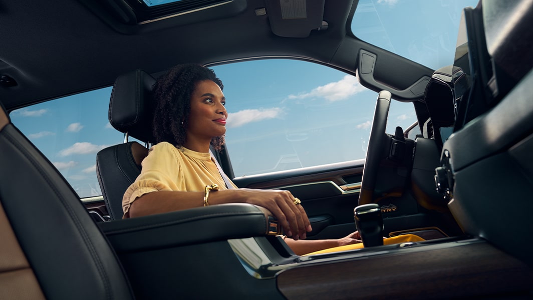 A woman driver resting her hand looking confident knowing OnStar has got her back.