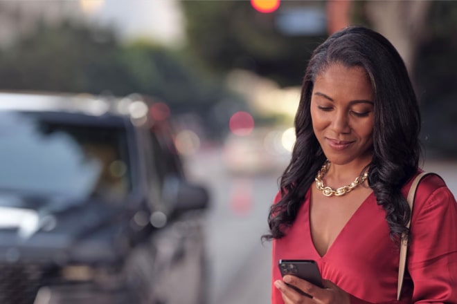 Woman looking at her phone and using the OnStar app.