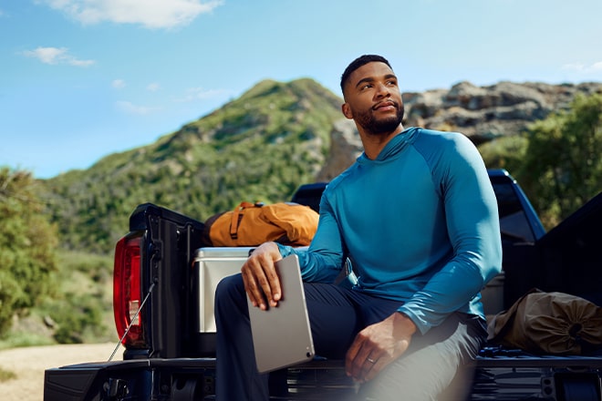 A man using OnStar's in-vehicle data to power his tablet.