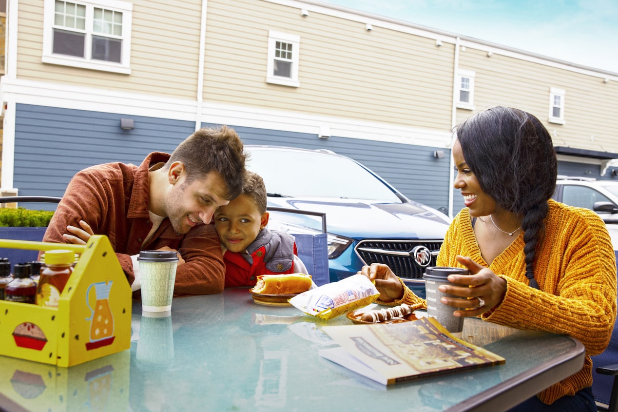 Family eating snacks together on a road trip supported by OnStar.